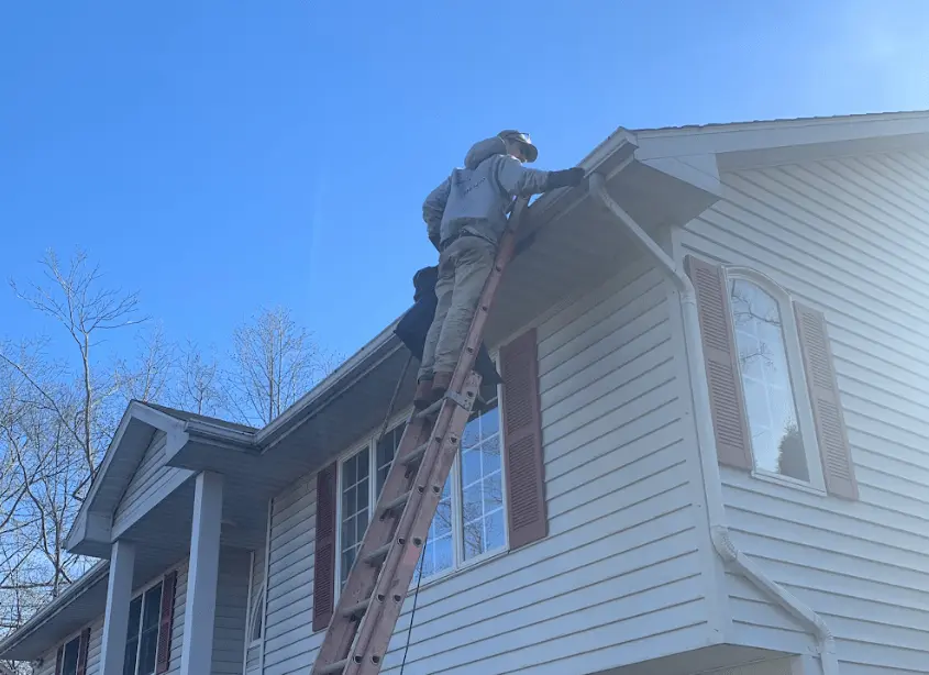 Gutter cleaning and maintenance being performed by Hudson Power Washing in Hudson